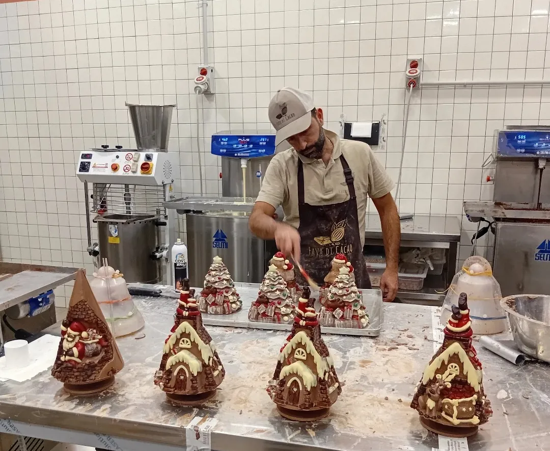 Nel laboratorio di Fava di Cacao si decorano a mano le casette di cioccolato per Natale
